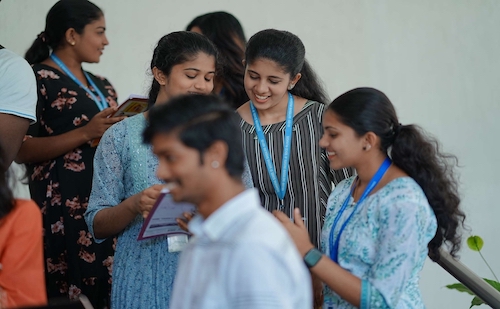 Campus view of students interacting in the S-VYASA School of Advanced Studies campus located in the Sattva Global City IT Park, Bengaluru, featuring modern buildings surrounded by lush greenery and state-of-the-art infrastructure.