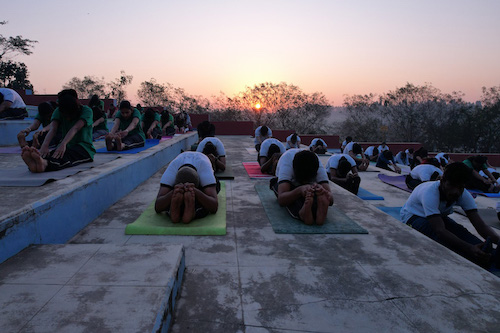 Students practicing yoga at S-VYASA School of Advanced Studies, located in Sattva Global City IT Park, Bengaluru, highlighting the integration of traditional Indian wellness practices with modern education on a serene, green campus.